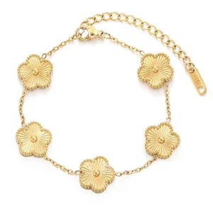 Primer plano del brazalete de trébol DEHO en acero quirúrgico con acabado en oro de 18 quilates y detalles de circonia Zona Tendencias